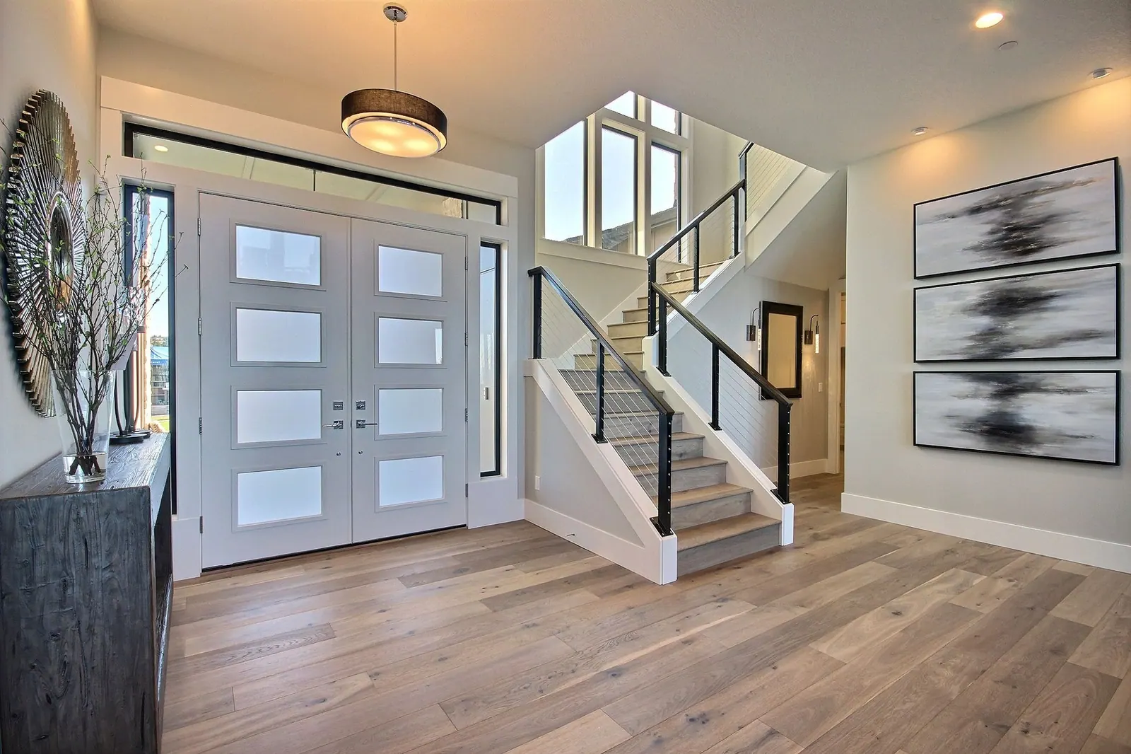 Entryway with light plank flooring running to a staircase in a Tulsa, OK home