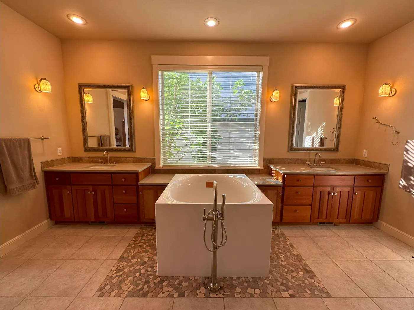 Tile bathroom floor around a freestanding tub and double vanity in a Tulsa metro home