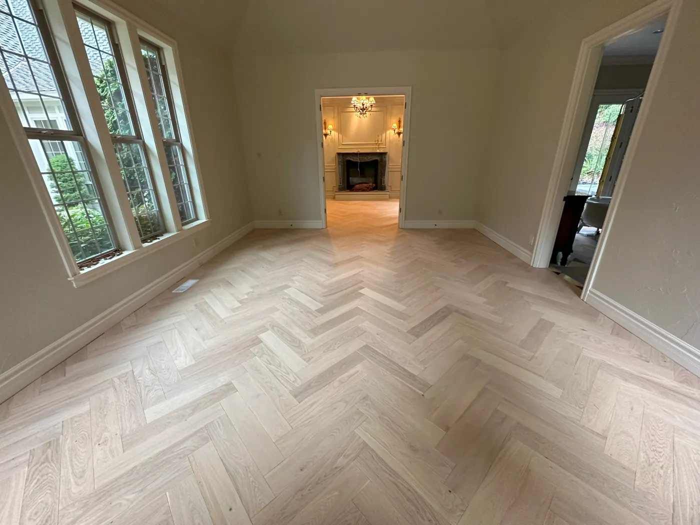 Herringbone plank flooring in a room with a bay window in a Tulsa, OK home
