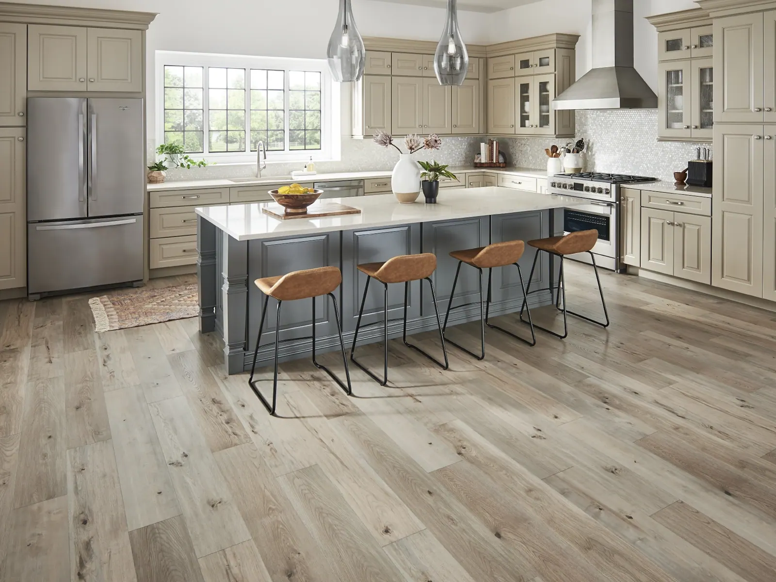 Gray toned plank flooring under a kitchen island with bar stools in a Tulsa metro home