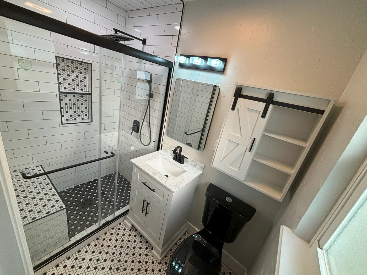 Patterned tile bathroom floor with a walk in shower and barn door in a Tulsa metro home
