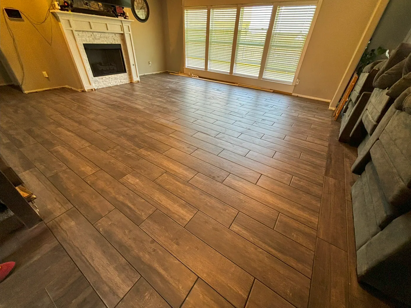 Wood look tile plank in a living room with shuttered windows